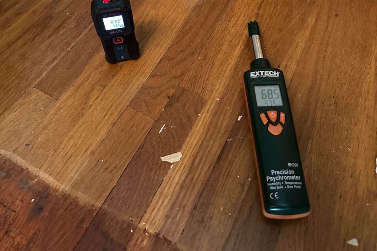 Handheld psychrometer and laser distance meter during a moisture inspection